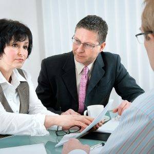 Divorce Challenges for Older Couples - woman and her lawyer in conversation with husband during divorce process