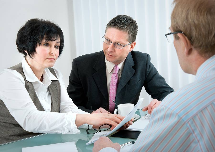 Divorce Challenges for Older Couples - woman and her lawyer in conversation with husband during divorce process