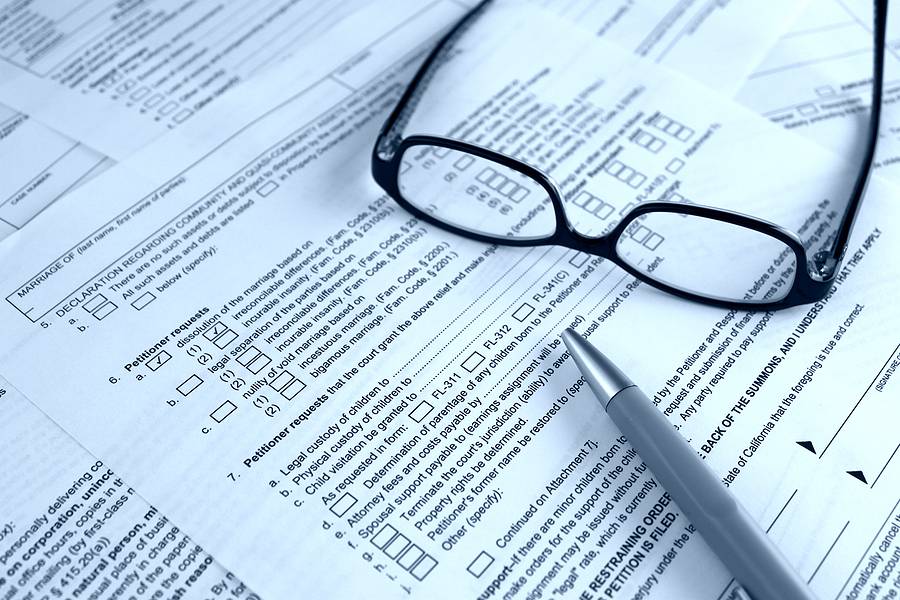 Relocation Disputes and Other Common Emergency Custody Triggers - legal law concept - court form for dissolution of marriage divorce on the foreground and glasses and a pen.