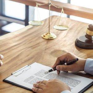 talking with a fort worth estate planning attorney at a wood desk with a gavel and scales of justice.